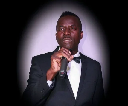 Dr Phil Soul Man singing into a microphone in a black suit and bowtie